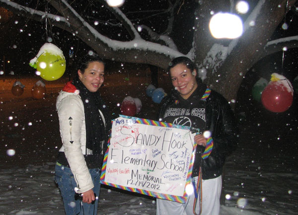 Two sisters, both students at UMF, freshman Mercedes Guillen, at left, and Maileny Guillen, set up an  remembrance for the victims of the shooting Friday at Sandy Hook Elementary School in Newtown, Conn. The students hung colorful balloons on a tree in front of UMF's Mantor Library and several students signed a big card offering their condolences as part of the impromptu memorial.