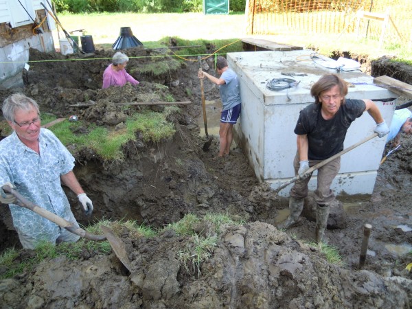Board members Paul Stancioff, Ellie Hopkins, Cynthia Stancioff and Jonathan Priest move mud to place footing forms for a privy.