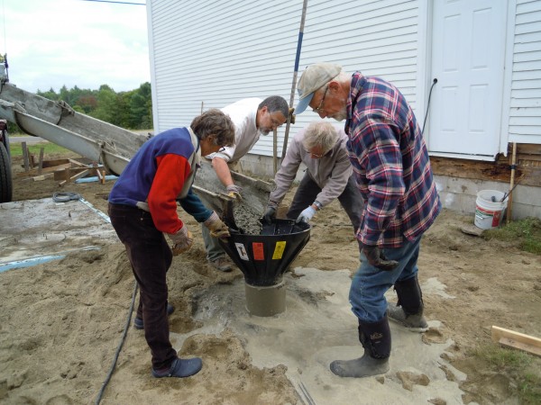 Board members Cynthia Stancioff, Rob Rogers, Paul Stancioff, and Fran Fuller monitor the pouring of concrete for the footings.