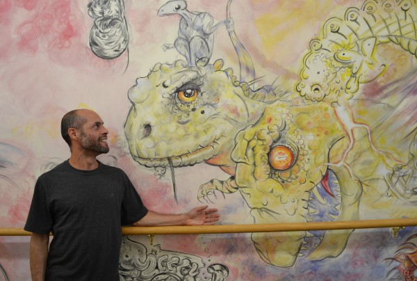 Ron Passerello stands in front of the mural he painted in Tranten's.